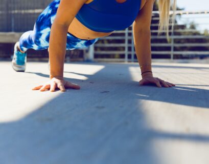 woman planking on gray asphalt road