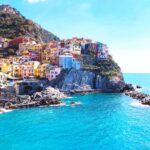 houses on mountain beside sea during daytime