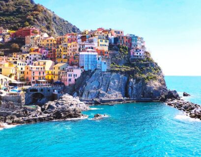 houses on mountain beside sea during daytime