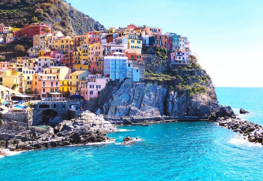 houses on mountain beside sea during daytime