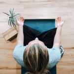 woman in black shirt and gray pants sitting on brown wooden bench