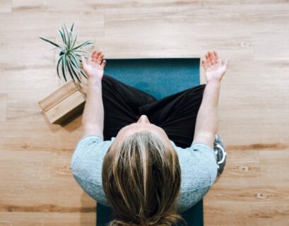 woman in black shirt and gray pants sitting on brown wooden bench