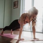 woman in black tank top and black leggings doing yoga