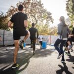 man in black t-shirt and black shorts running on road during daytime