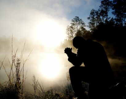 silhouette of kneeling man