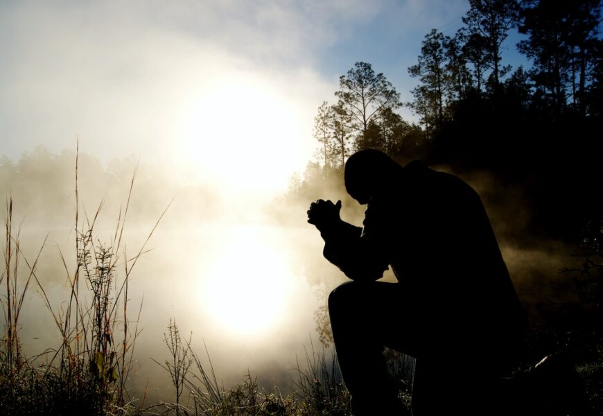 silhouette of kneeling man