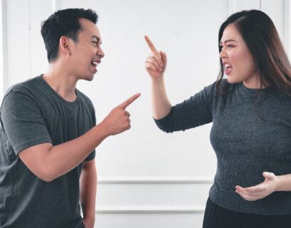 man in gray crew neck long sleeve shirt standing beside woman in black crew neck shirt