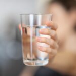 person holding clear drinking glass