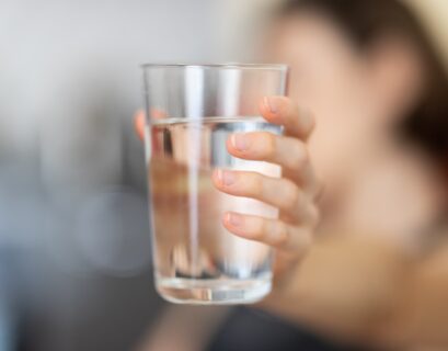 person holding clear drinking glass