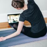 woman in black t-shirt and black pants lying on black yoga mat