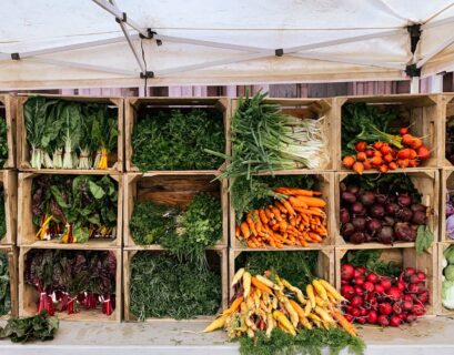 a variety of vegetables are displayed in wooden crates