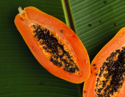 sliced papaya on green banana leaf